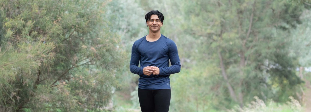 Man in ioMerino outdoor clothing standing outdoors with the parklands behind him