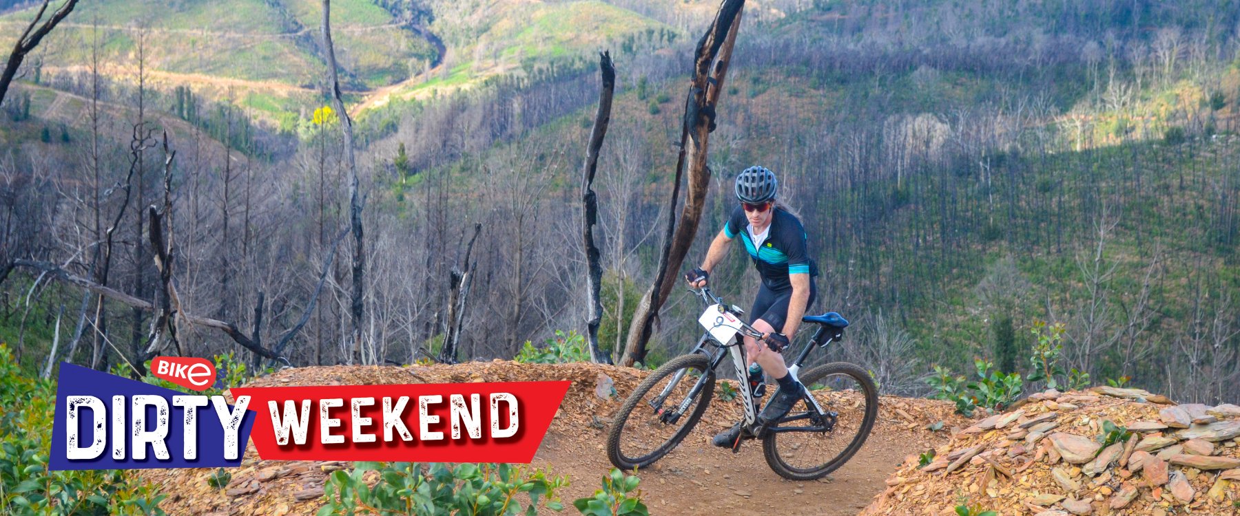 An image of someone mountain biking up a trail. Text in the bottom left corner reads BikE Dirty Weekend.