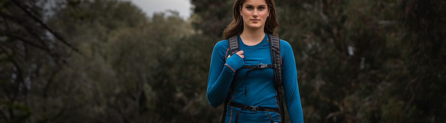 Woman hiking in the outdoors wearing a blue Ultra Crew Neck Top